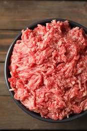 Photo of Raw ground meat in bowl on wooden table, top view