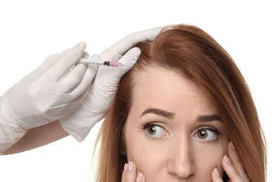 Photo of Young woman with hair loss problem receiving injection, on white background