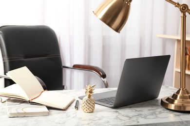 Photo of Stylish workplace with different golden accessories indoors. Idea for interior design