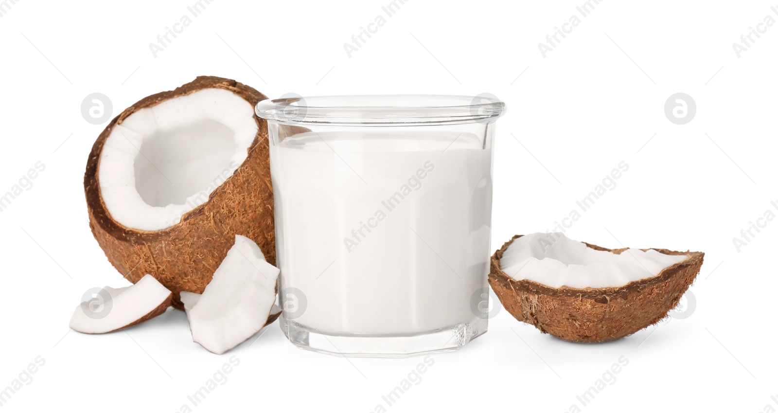 Photo of Glass of delicious vegan milk and coconut pieces on white background