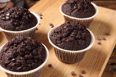 Photo of Tasty chocolate muffins on wooden table, closeup