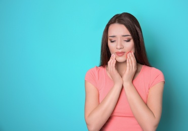 Woman with sensitive teeth on color background