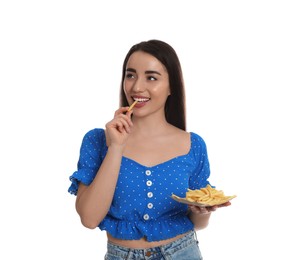 Beautiful young woman eating French fries on white background