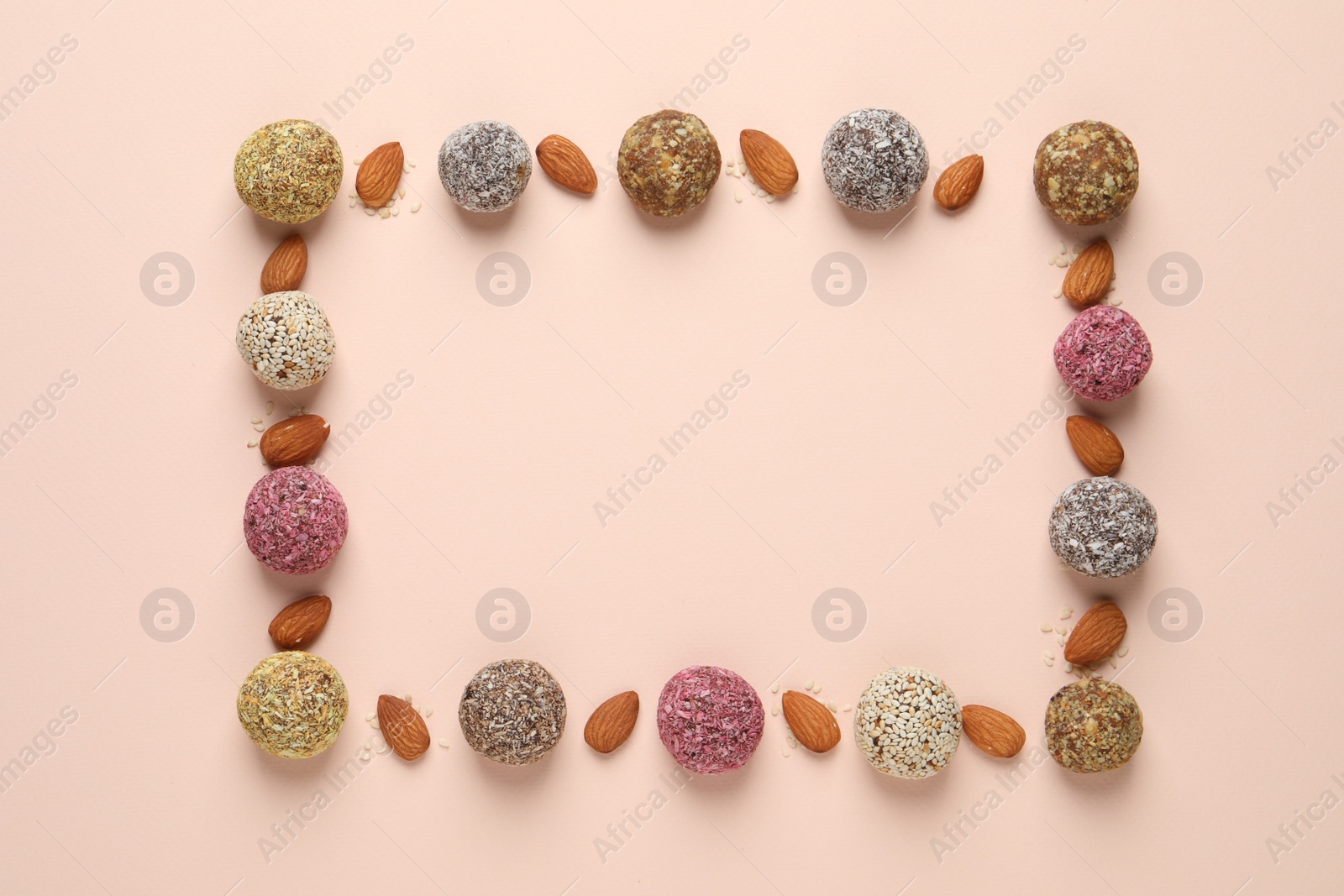 Photo of Frame of delicious vegan candy balls and almonds on light background, flat lay. Space for text