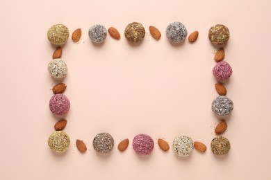 Frame of delicious vegan candy balls and almonds on light background, flat lay. Space for text