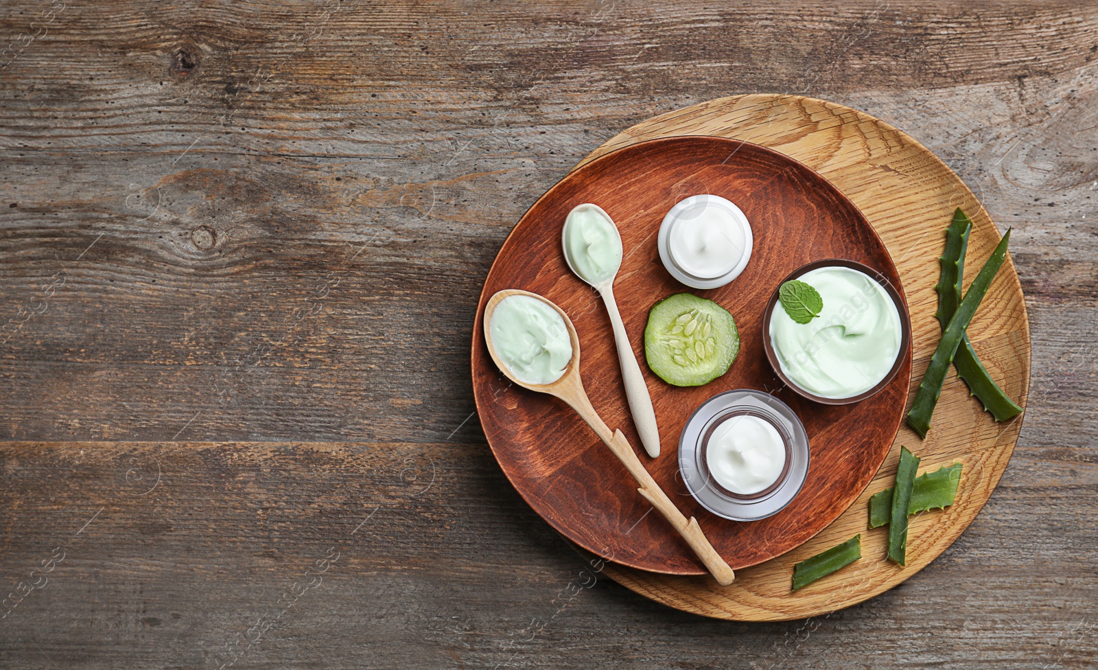 Photo of Composition with body cream in jars on wooden background, top view