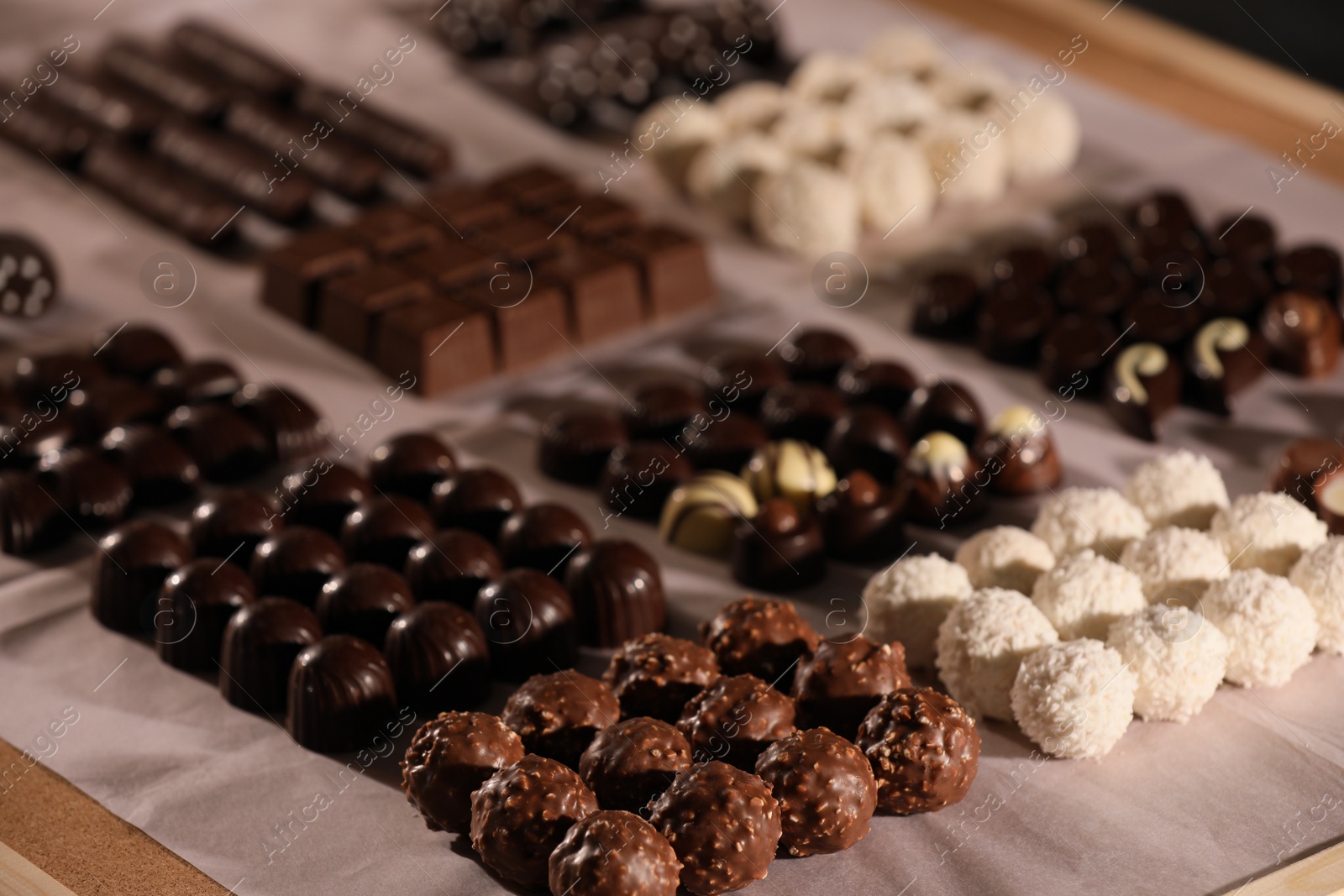 Photo of Many delicious chocolate candies on table, closeup. Production line