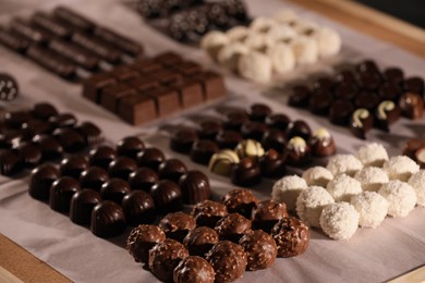 Many delicious chocolate candies on table, closeup. Production line
