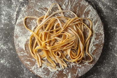 Photo of Uncooked homemade pasta on dark grey table, top view