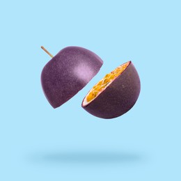 Image of Halves of passion fruit falling on light blue background