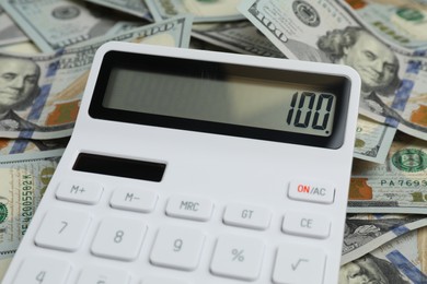 Photo of Money exchange. Dollar banknotes and calculator, closeup