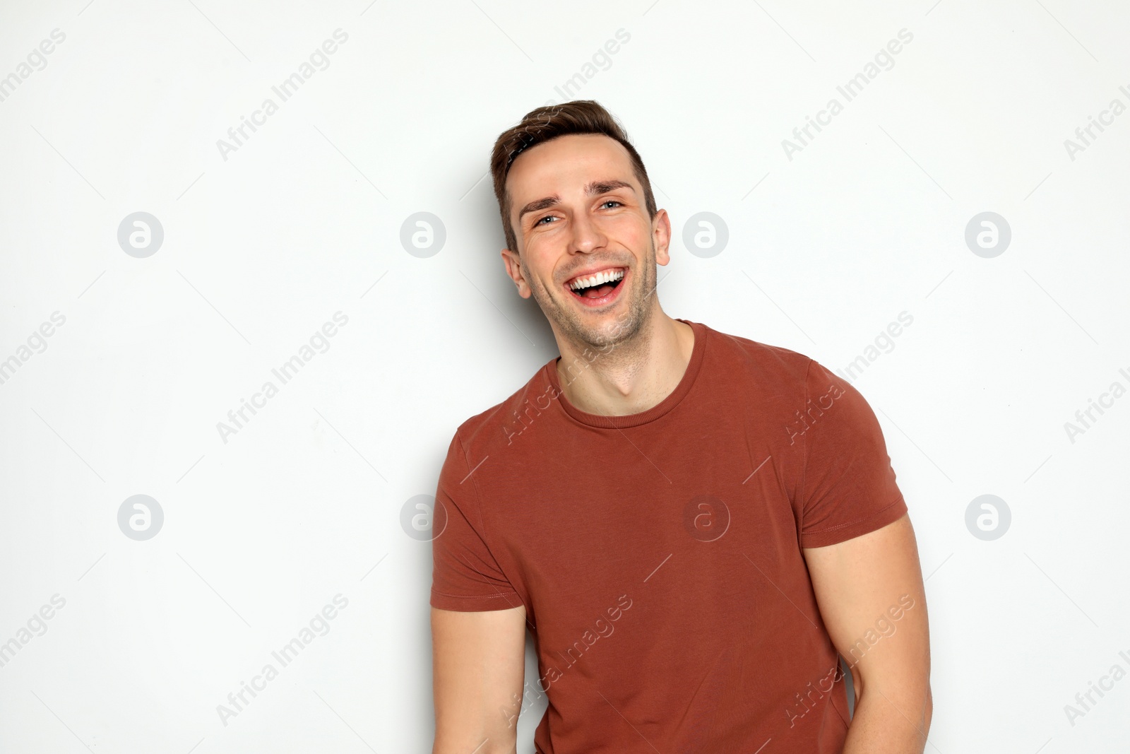 Photo of Portrait of handsome man laughing against light background