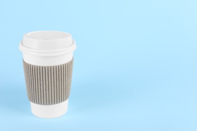 Photo of Paper cup with plastic lid on light blue background, space for text. Coffee to go