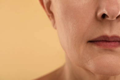 Photo of Woman with normal skin on beige background, macro view. Space for text