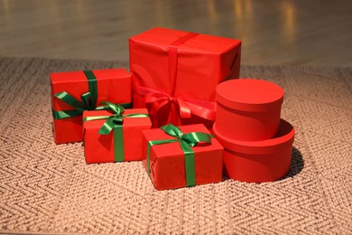 Photo of Beautifully wrapped Christmas gifts on rug indoors