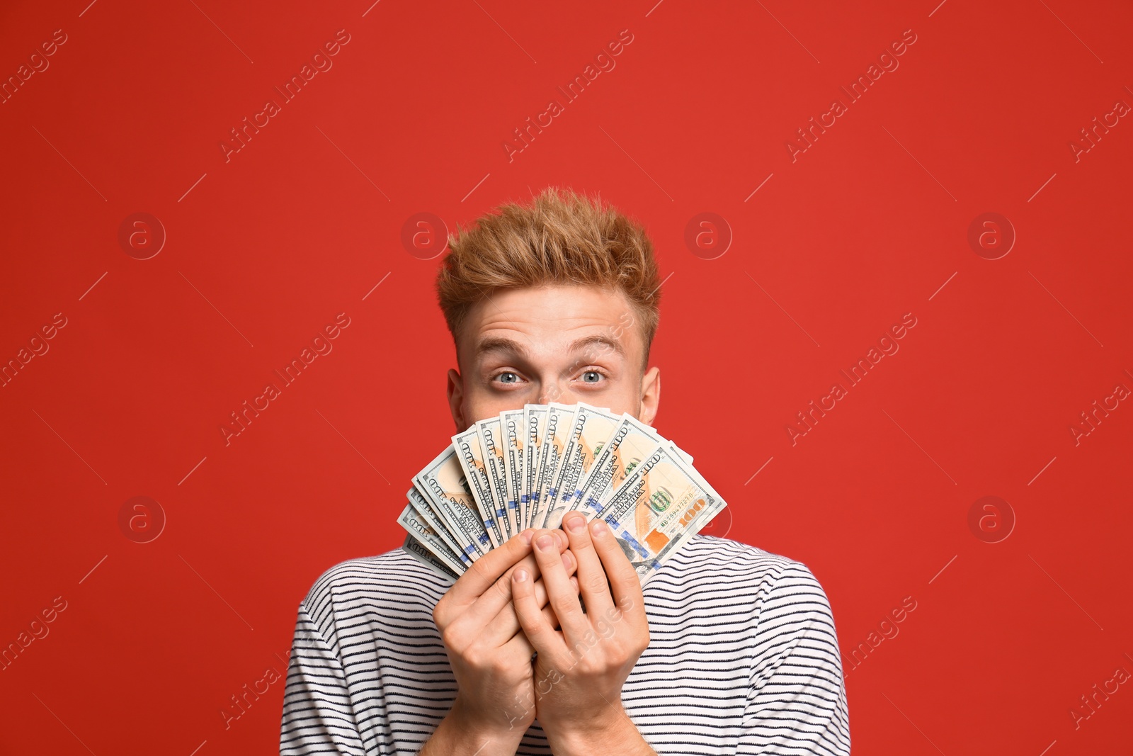 Photo of Portrait of surprised lottery winner with money on red background