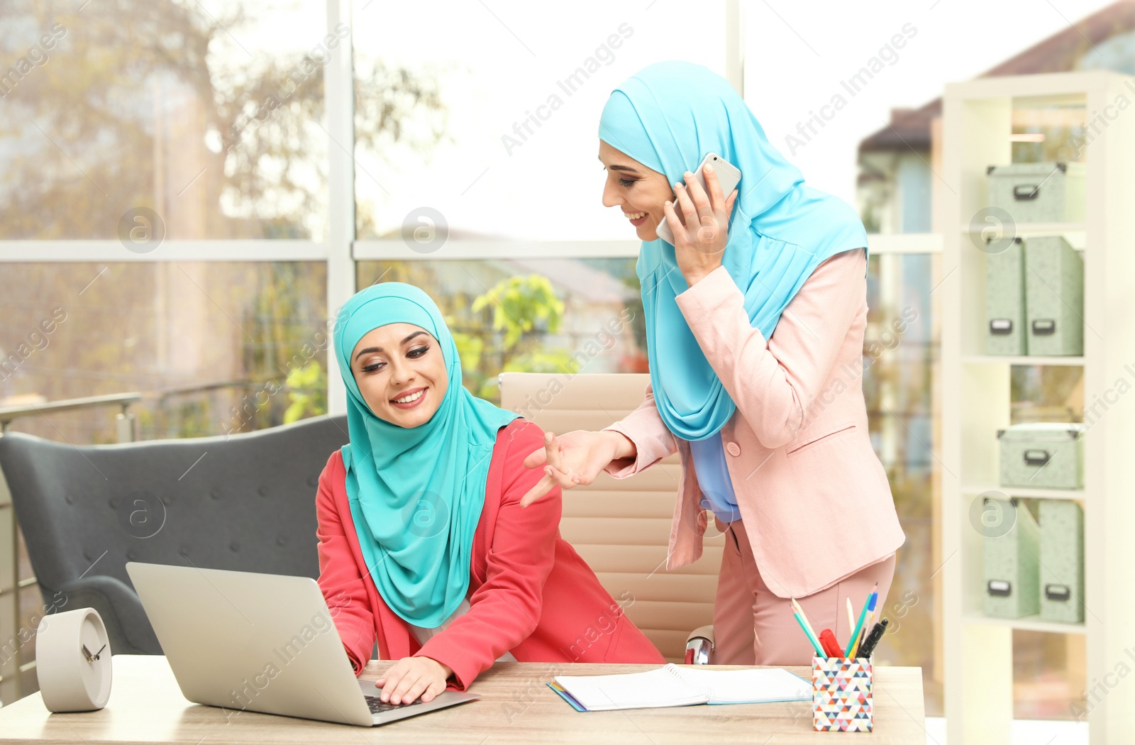 Photo of Modern Muslim women working in light office