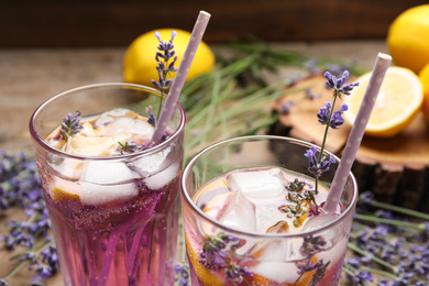 Fresh delicious lemonade with lavender and straws on table, closeup