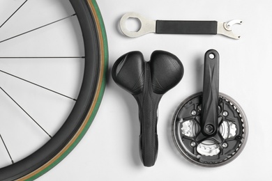 Photo of Set of different bicycle parts and tool on white background, flat lay