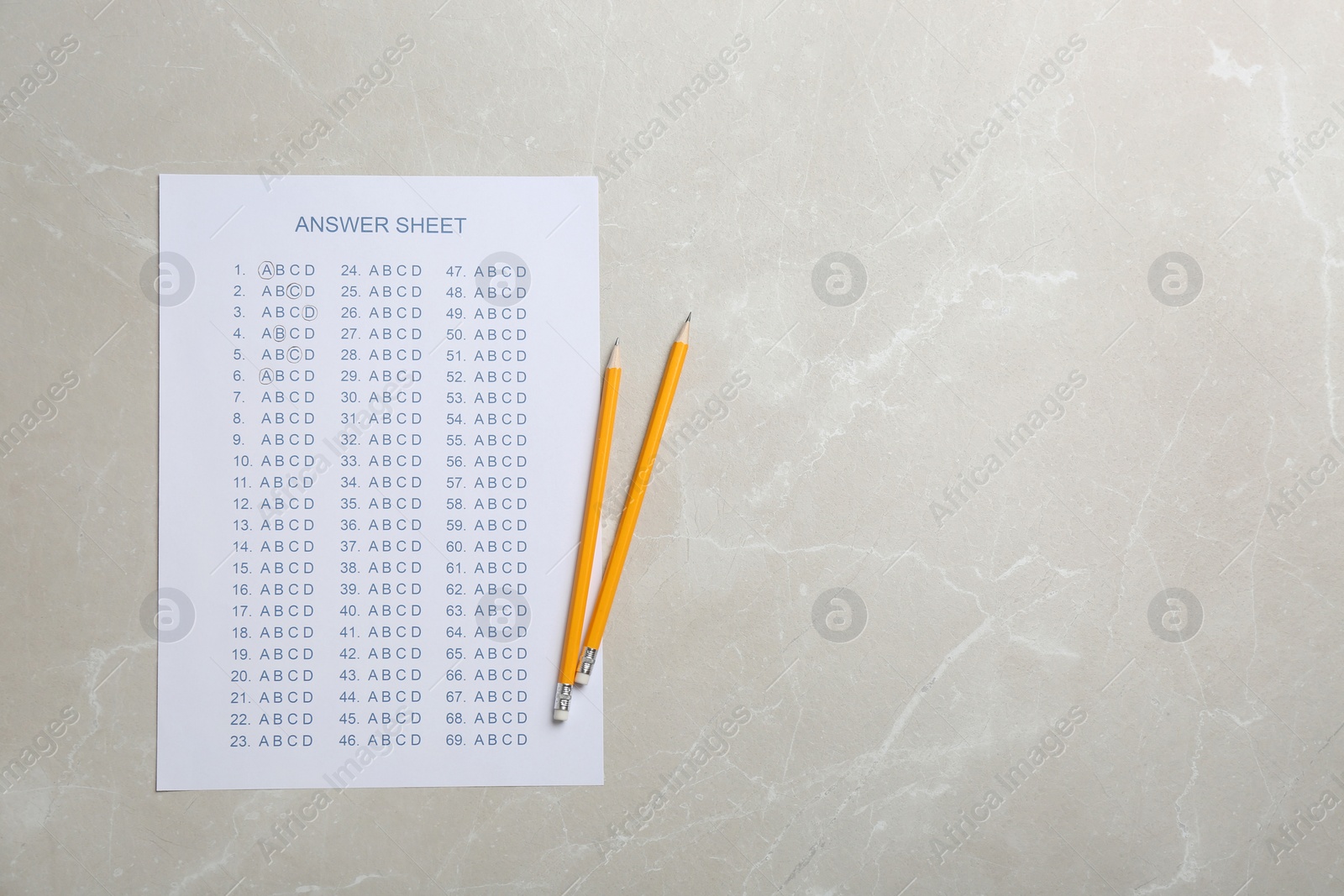 Photo of Answer sheet and pencils on grey background, top view with space for text