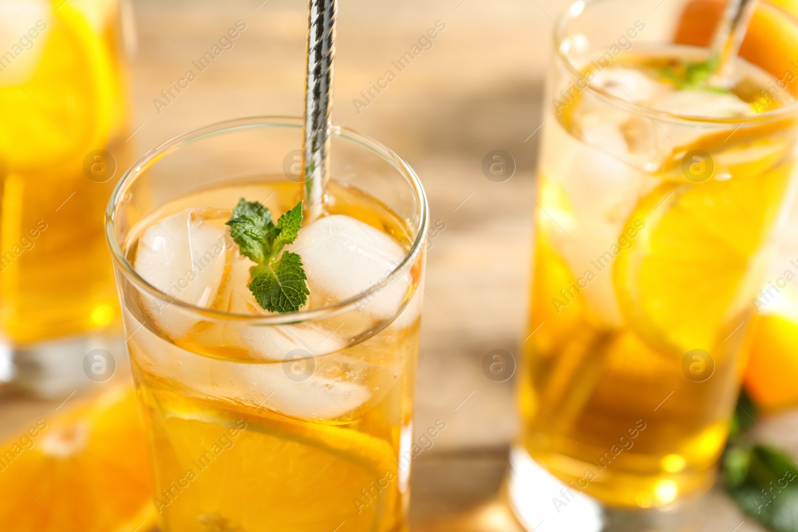 Photo of Delicious refreshing drink with orange slices on table, closeup