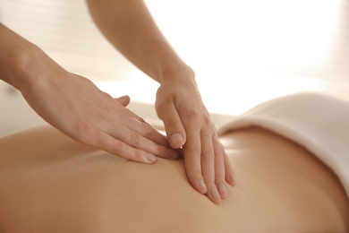 Young woman receiving back massage in spa salon, closeup