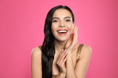 Portrait of surprised woman on pink background