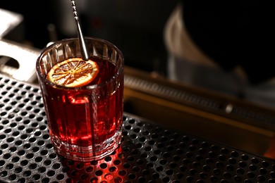 Photo of Fresh alcoholic cocktail on counter in bar, closeup. Space for text