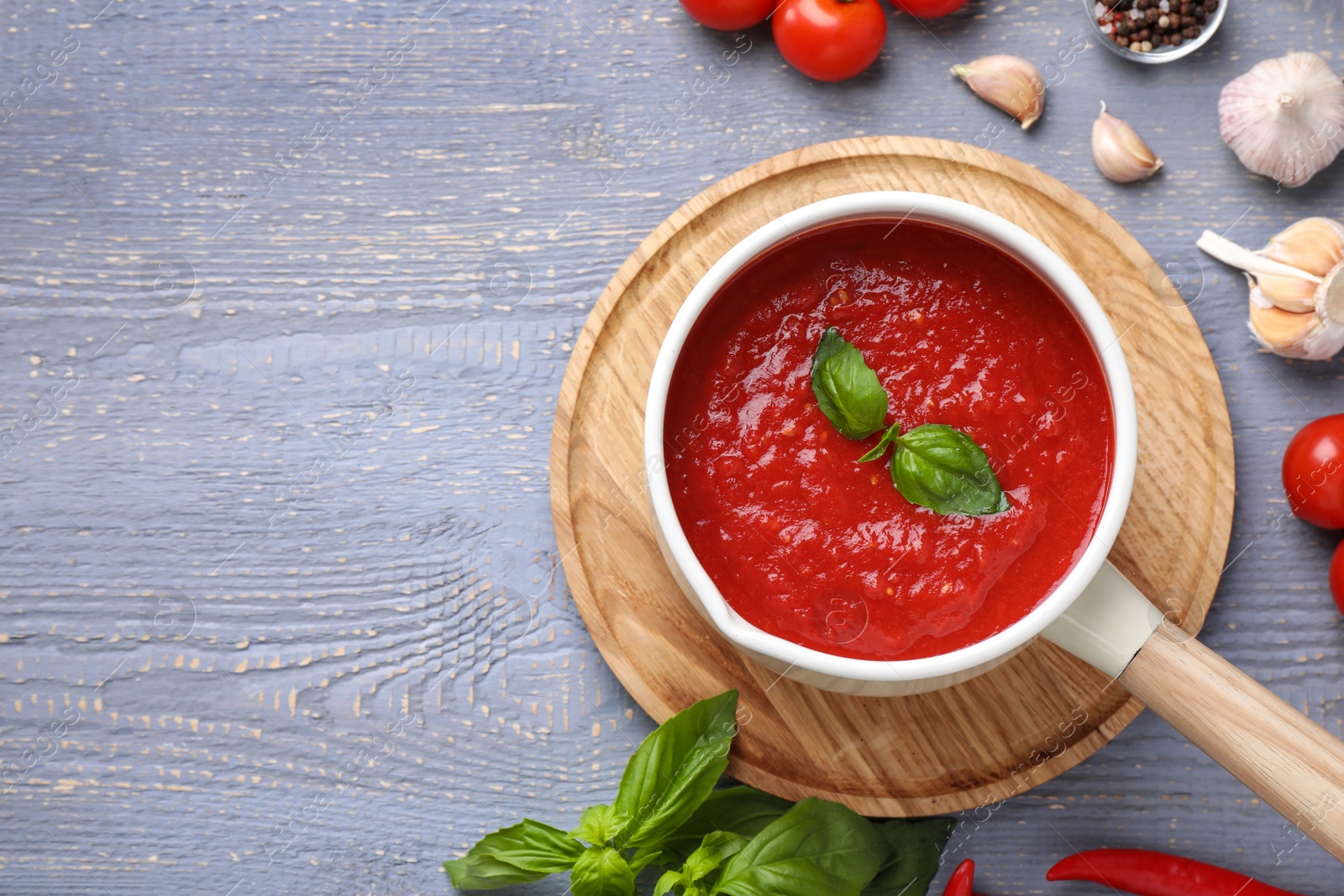 Photo of Delicious tomato sauce on grey wooden table, flat lay. Space for text