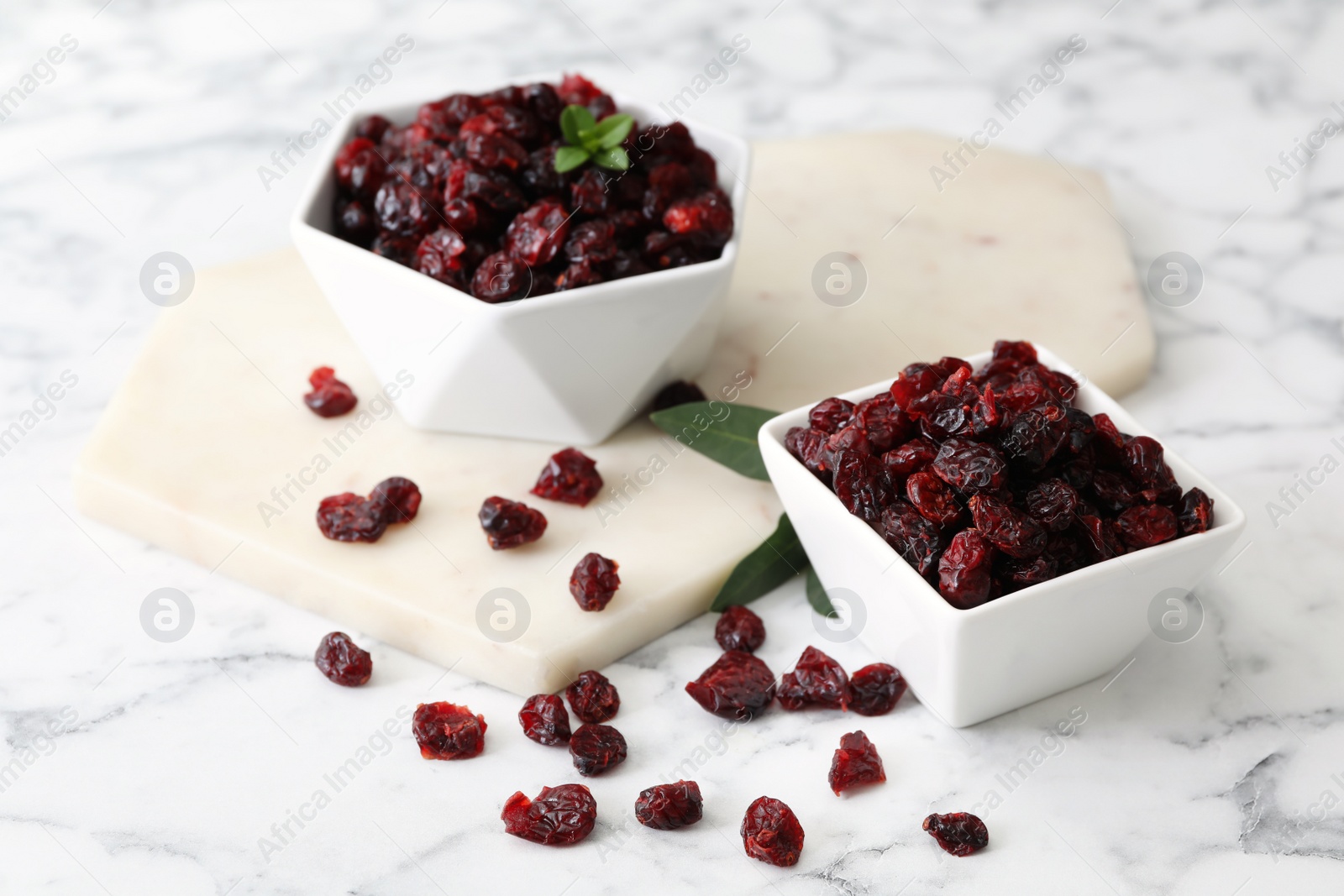 Photo of Composition with tasty dried cranberries on white marble table