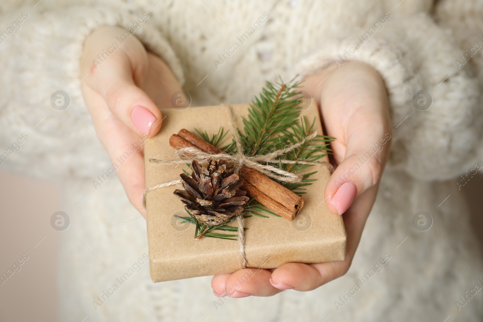 Photo of Christmas present. Woman holding beautifully wrapped gift box, closeup