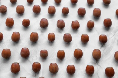 Photo of Brown tasty hazelnuts on light marble table