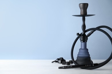 Photo of Traditional hookah on white table. Space for text