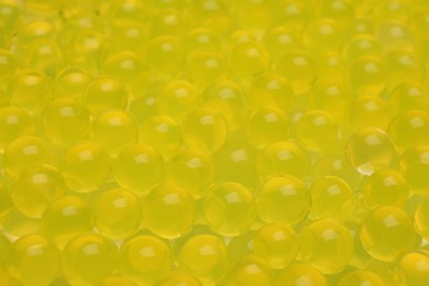 Photo of Closeup view of yellow vase filler as background. Water beads