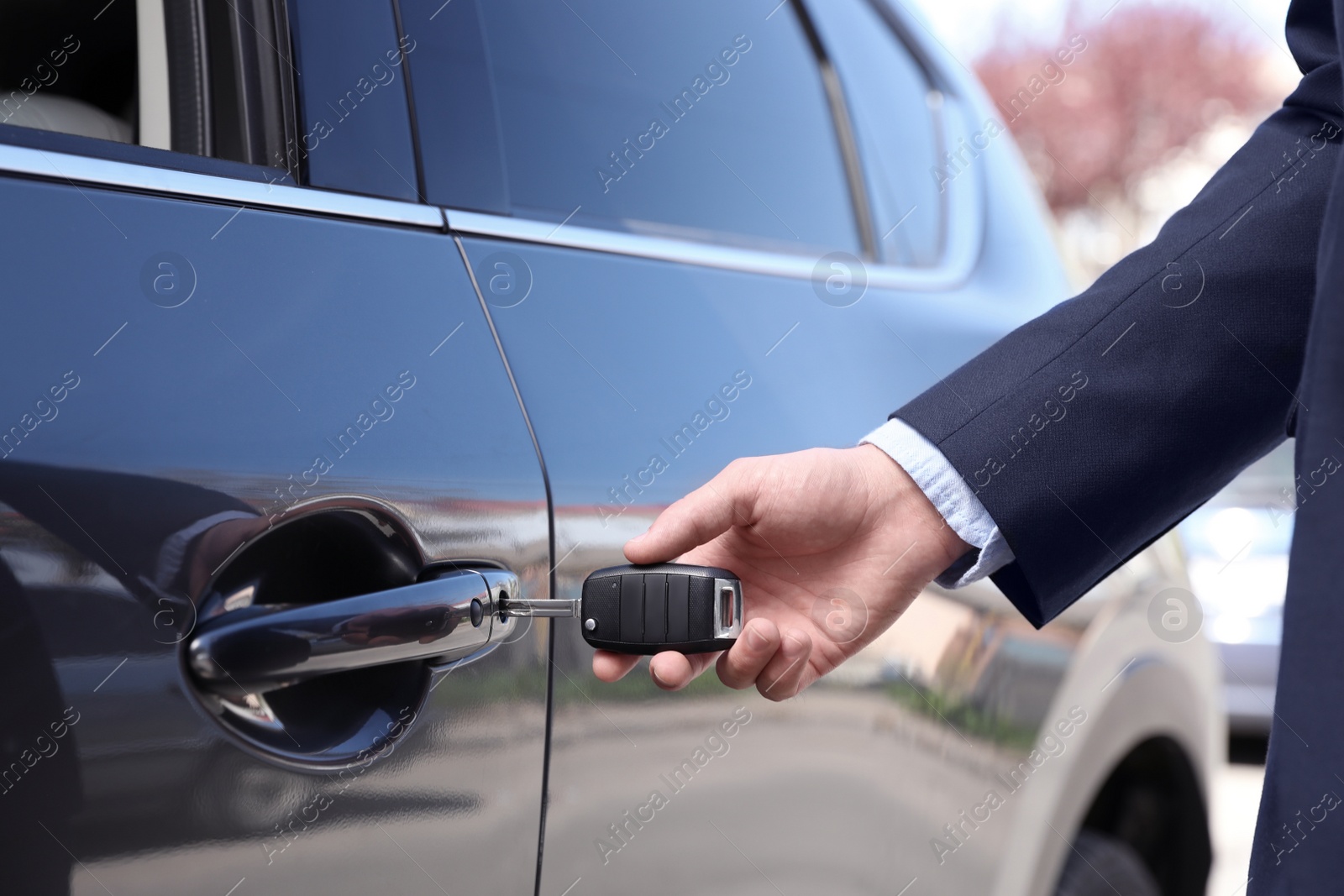 Photo of Businessman opening car door with key, closeup