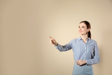 Portrait of young female teacher on beige background. Space for text