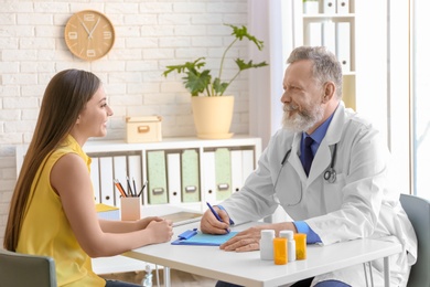 Photo of Mature doctor consulting patient in clinic