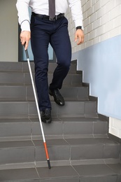 Photo of Blind person with long cane going down stairs, closeup