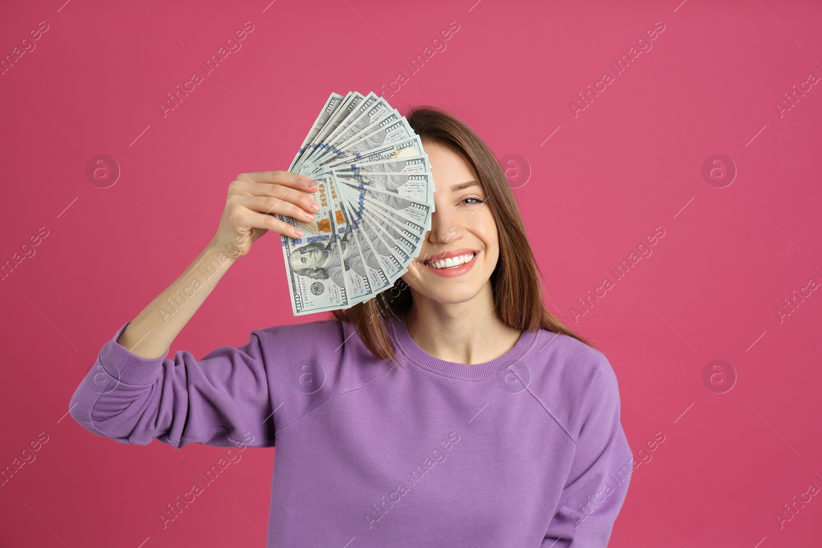 Photo of Happy young woman with cash money on pink background