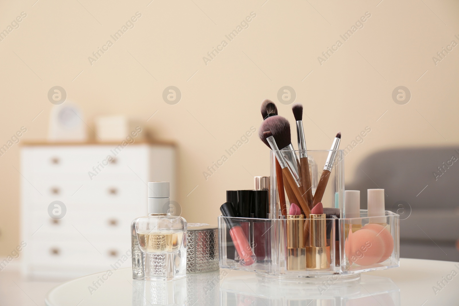 Photo of Organizer with cosmetic products for makeup on table indoors