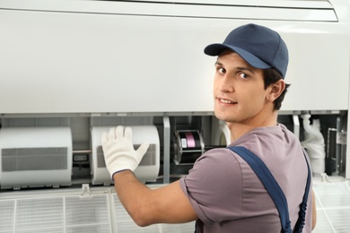 Photo of Technician installing and checking air conditioner indoors