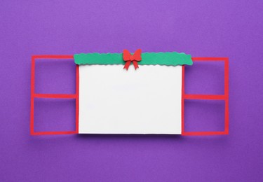 Photo of Open paper window frame with Christmas decoration on purple background. Space for text