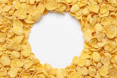 Frame of sweet tasty corn flakes on white background, top view. Space for text