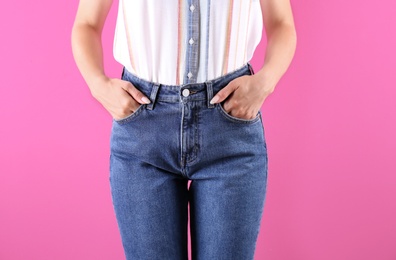 Photo of Woman in stylish blue jeans on color background