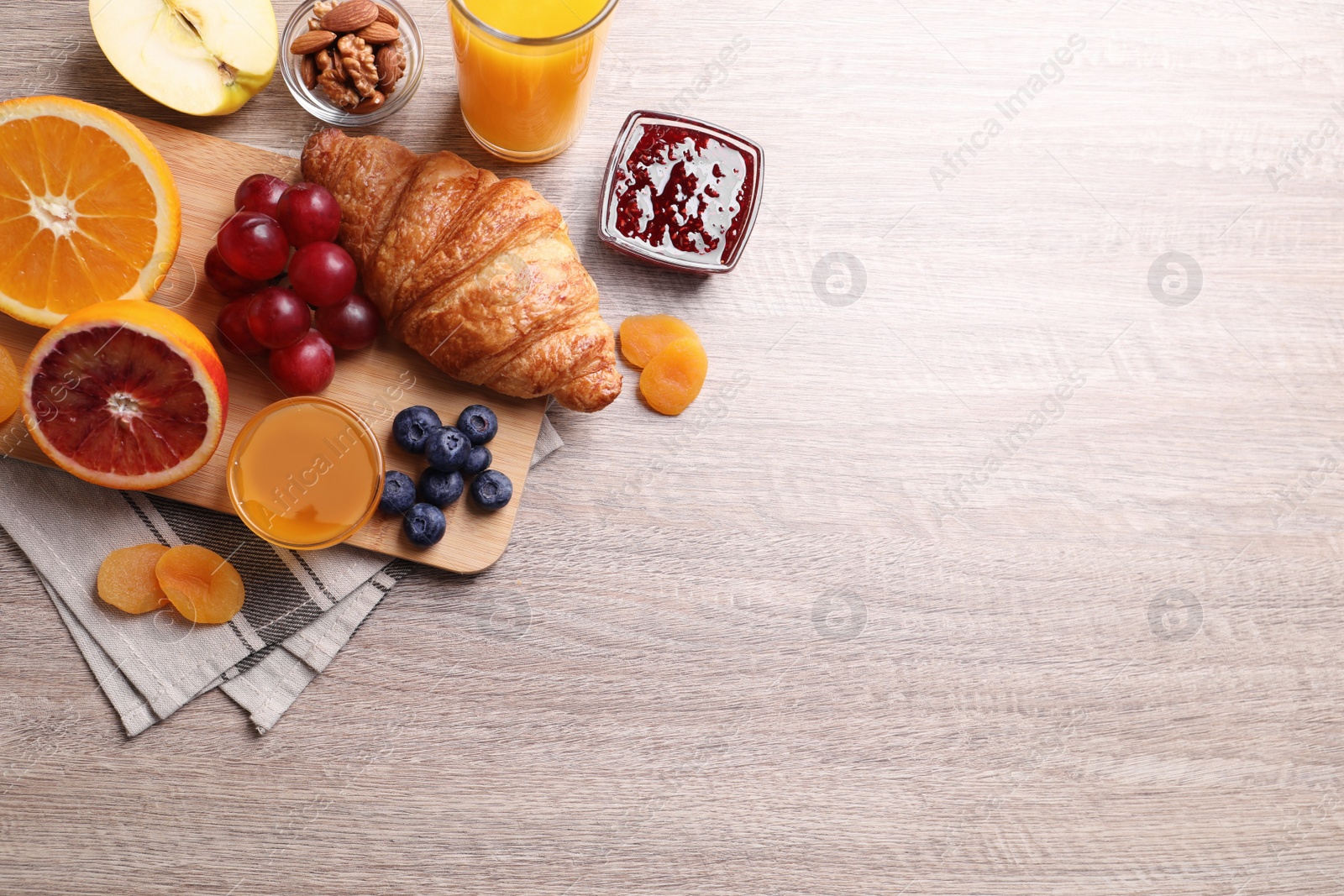 Photo of Delicious breakfast with croissant on wooden table, flat lay. Space for text