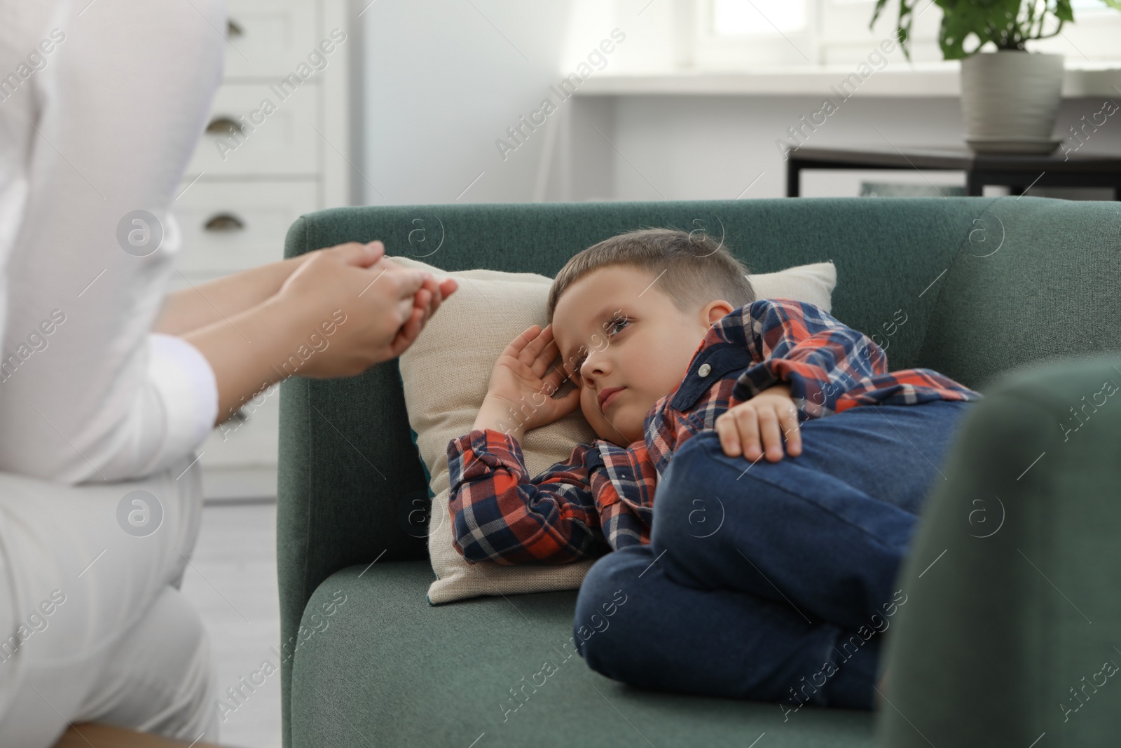 Photo of Psychologist working with unhappy little boy in office. Mental health problems