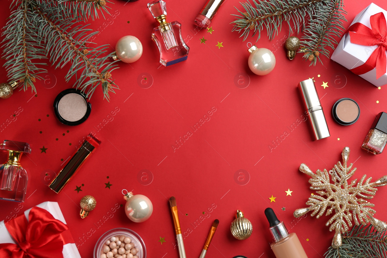 Photo of Frame of decorative cosmetic products on red background, flat lay with space for text. Winter care