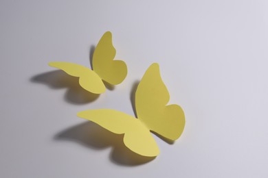 Yellow paper butterflies on light background. Space for text