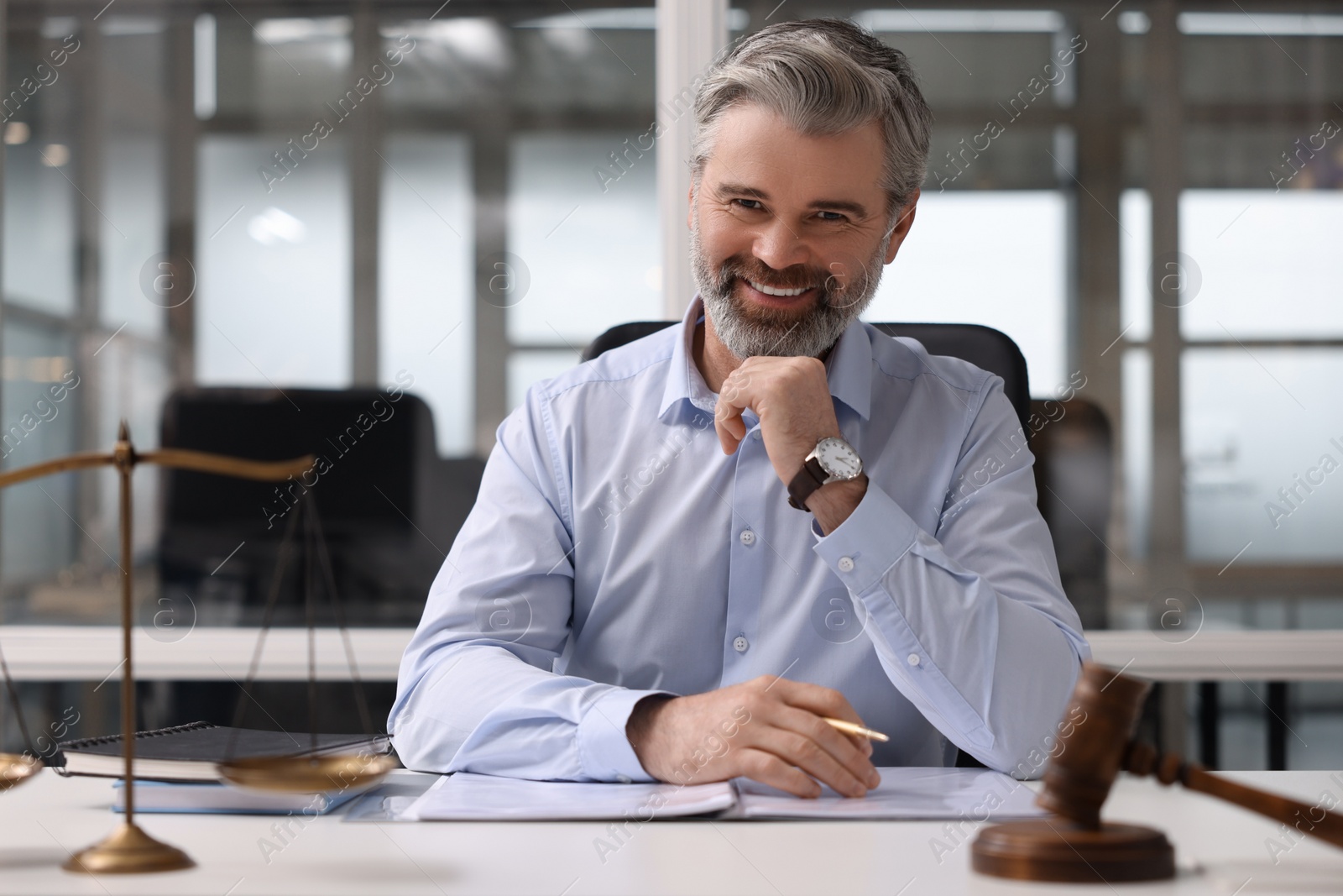 Photo of Portrait of smiling lawyer at table in office