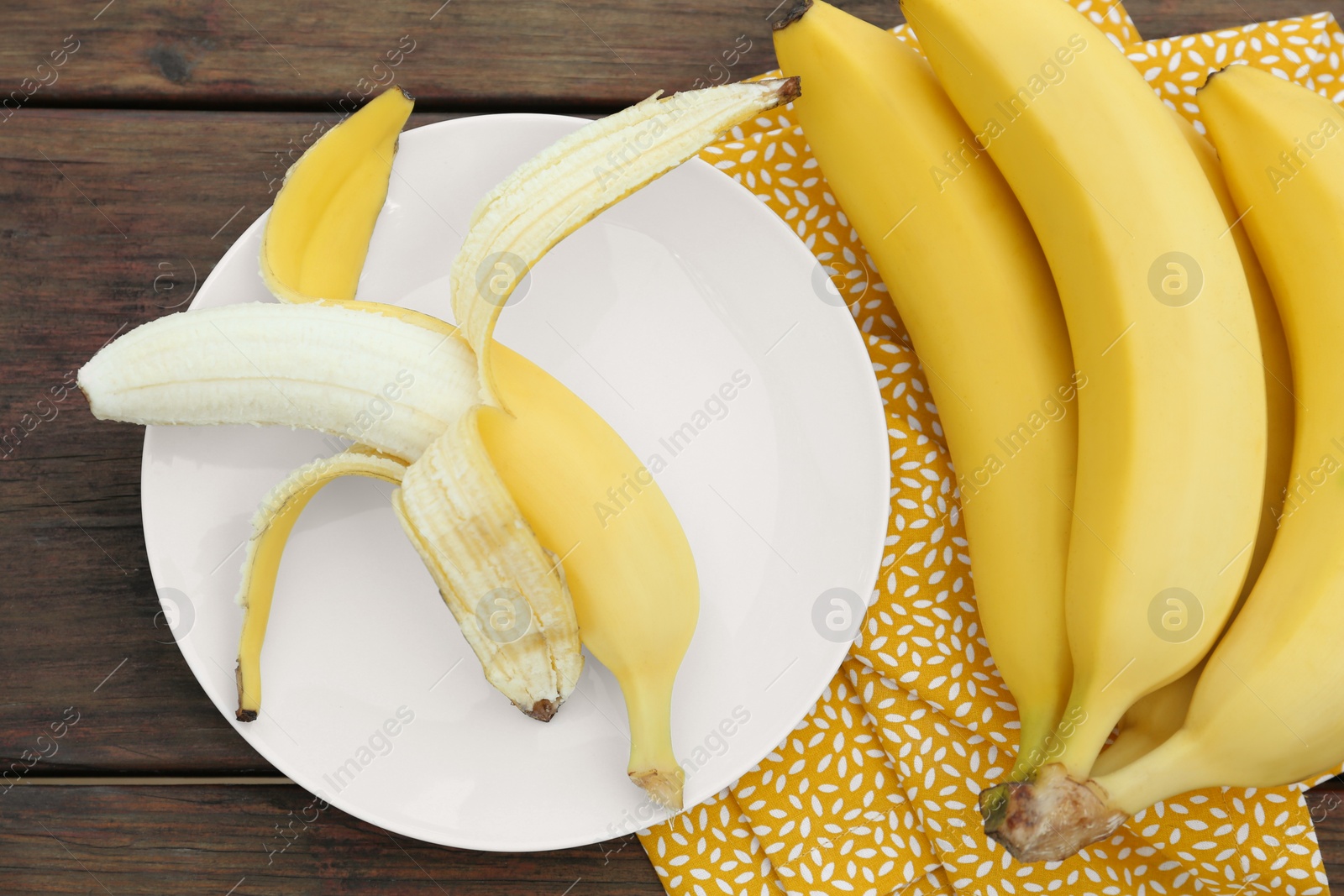 Photo of Many delicious ripe bananas on wooden table, flat lay